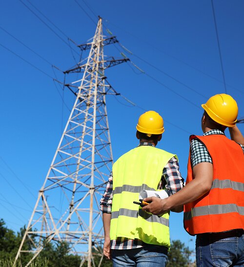 Two Forbes Bros workers looking up at a transmission tower